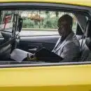 Pensive black entrepreneur examining important report in car