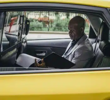 Pensive black entrepreneur examining important report in car