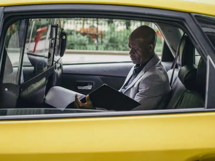 Pensive black entrepreneur examining important report in car