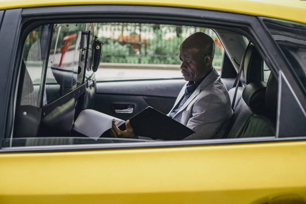 Pensive black entrepreneur examining important report in car