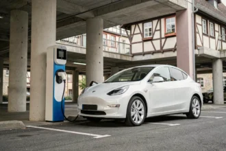 Borne de recharge pour véhicule électrique dans un parking à Colmar avec architecture alsacienne en arrière-plan