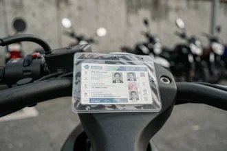 Porte vignette assurance moto transparent fixé sur le guidon, avec certificat d'assurance visible