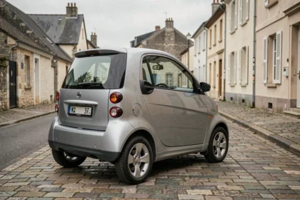 Voiture sans permis grise garée dans une rue résidentielle française avec badge boîte automatique visible